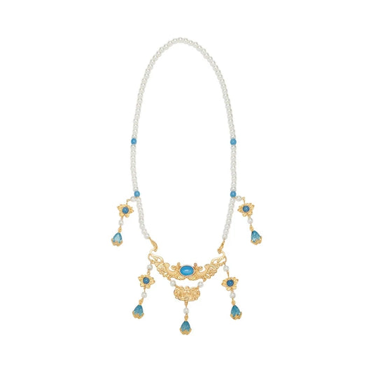Blue pendant necklace with pearls and gold details, isolated on white background