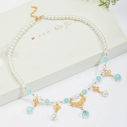 Blue pumpkin bead necklace with pearls and gold details, displayed on white box, light background