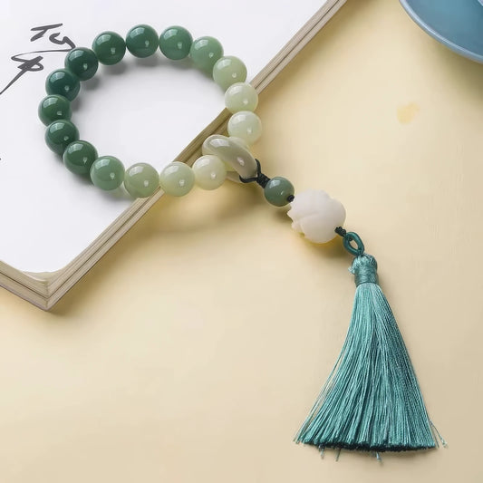 Bodhi lotus tassel prayer beads with solid green tassel, placed on beige background