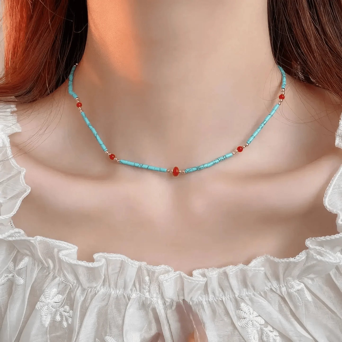 Single - layer bohemian stone bead necklace, turquoise and red beads, worn on ruffled top
