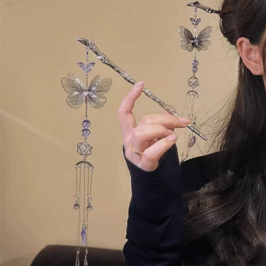 Hand holding silver butterfly amethyst tassel hairpin, light background, comparing styles