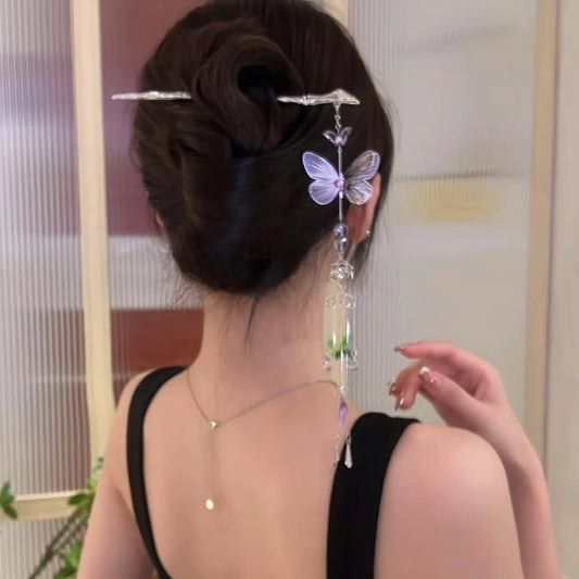 Silver butterfly amethyst tassel hairpin worn in an updo hairstyle, black clothing background, purple butterfly wings