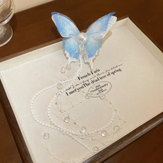 Blue butterfly bow pearl tassel hair clip isolated on a white card