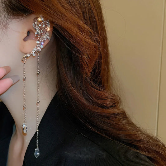Butterfly crystal tassel ear cuff worn, black clothing background