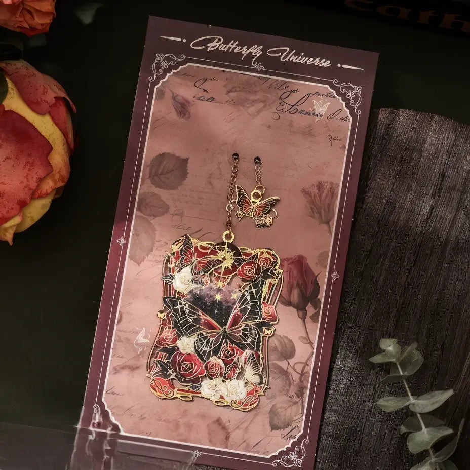 Multiple butterfly - shaped metal lattice bookmarks in different colored packages, arranged on a vintage table with flowers and greenery, realistic product display style, 3:4 ratio