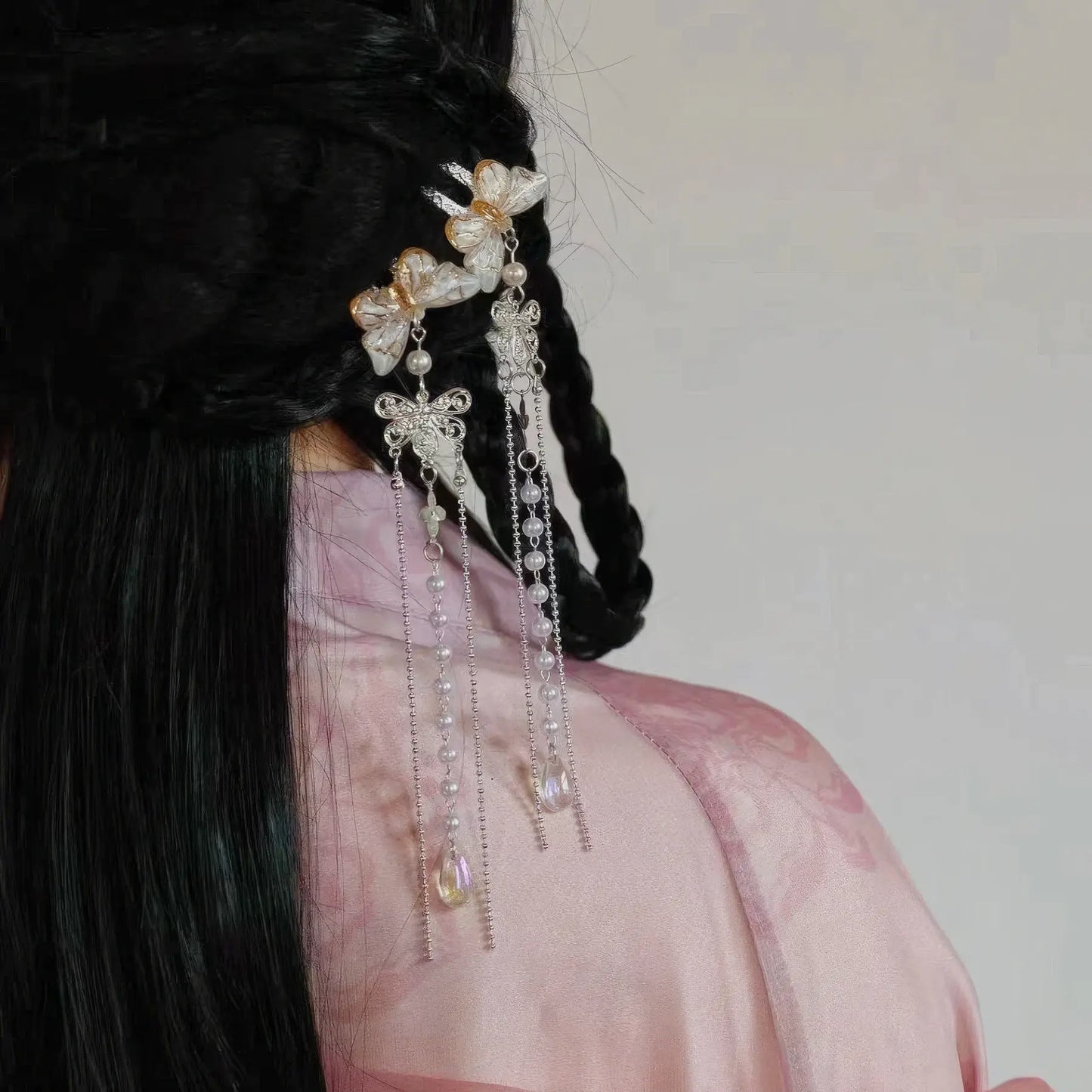 Another view of butterfly pearl small U - hairpin tassel worn on a traditional hairstyle with pink clothing