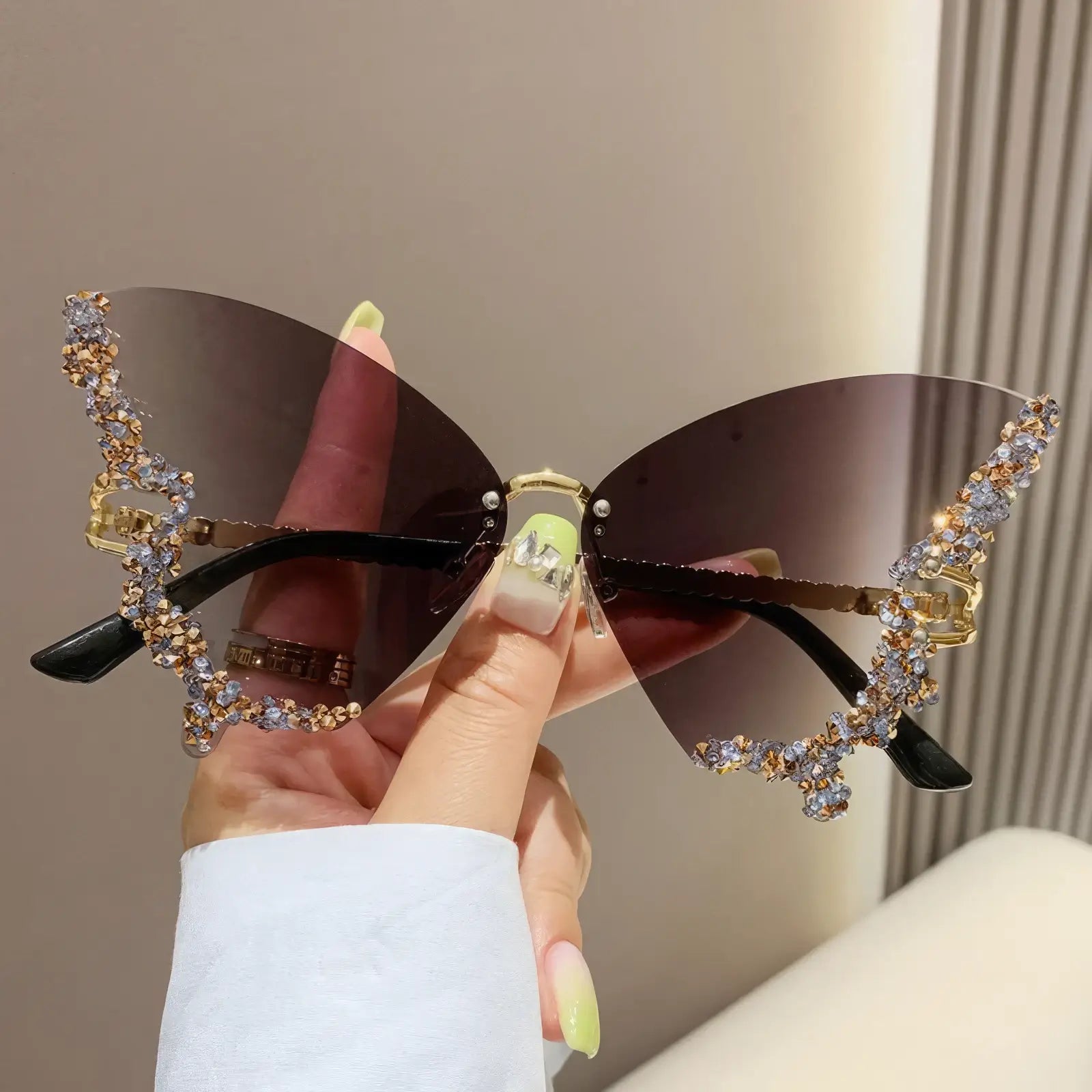 Butterfly - shaped sunglasses with brown lenses and rhinestone details