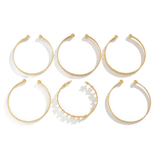 Set of gold carved pattern flower bangles, isolated on white background