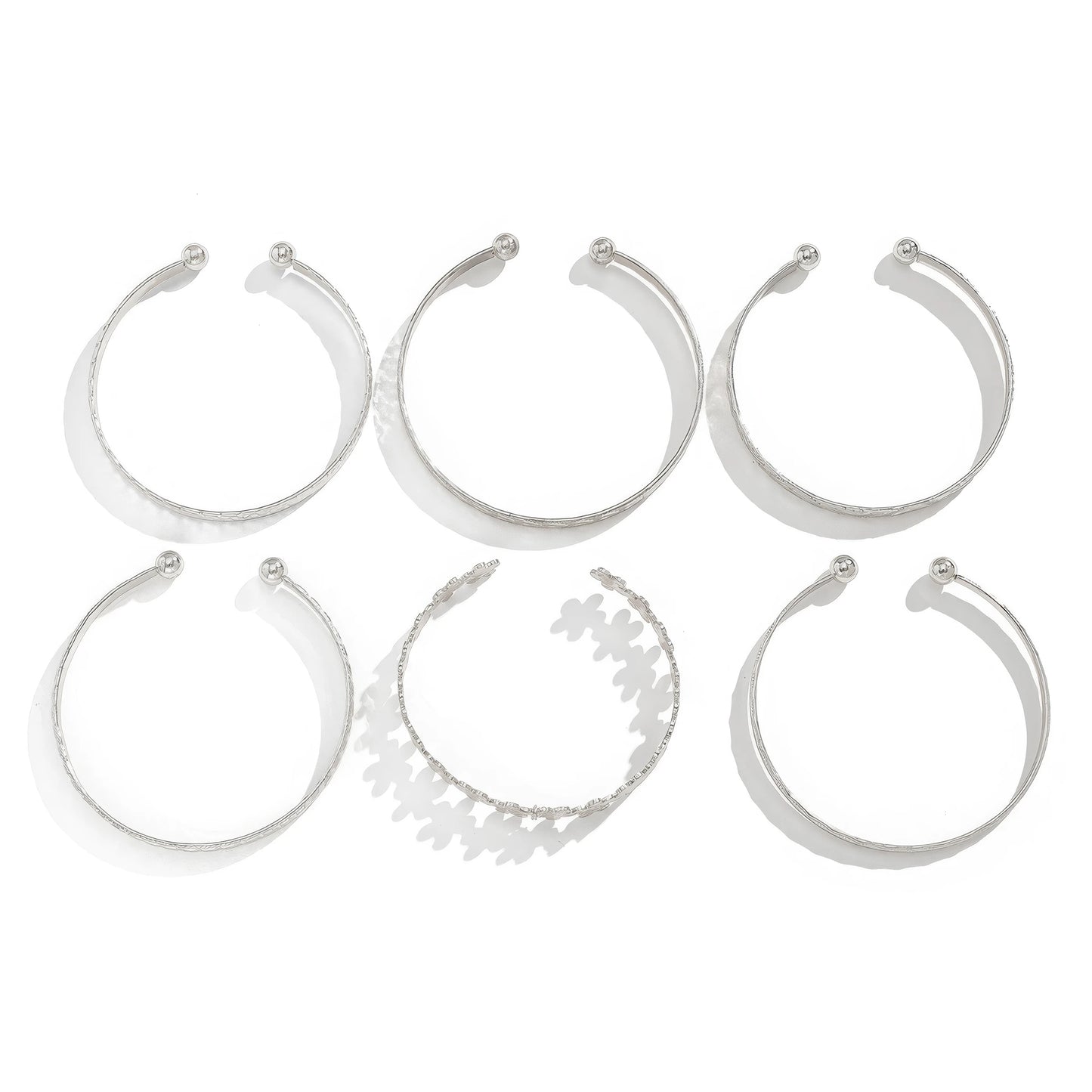 Set of silver carved pattern flower bangles, isolated on white background
