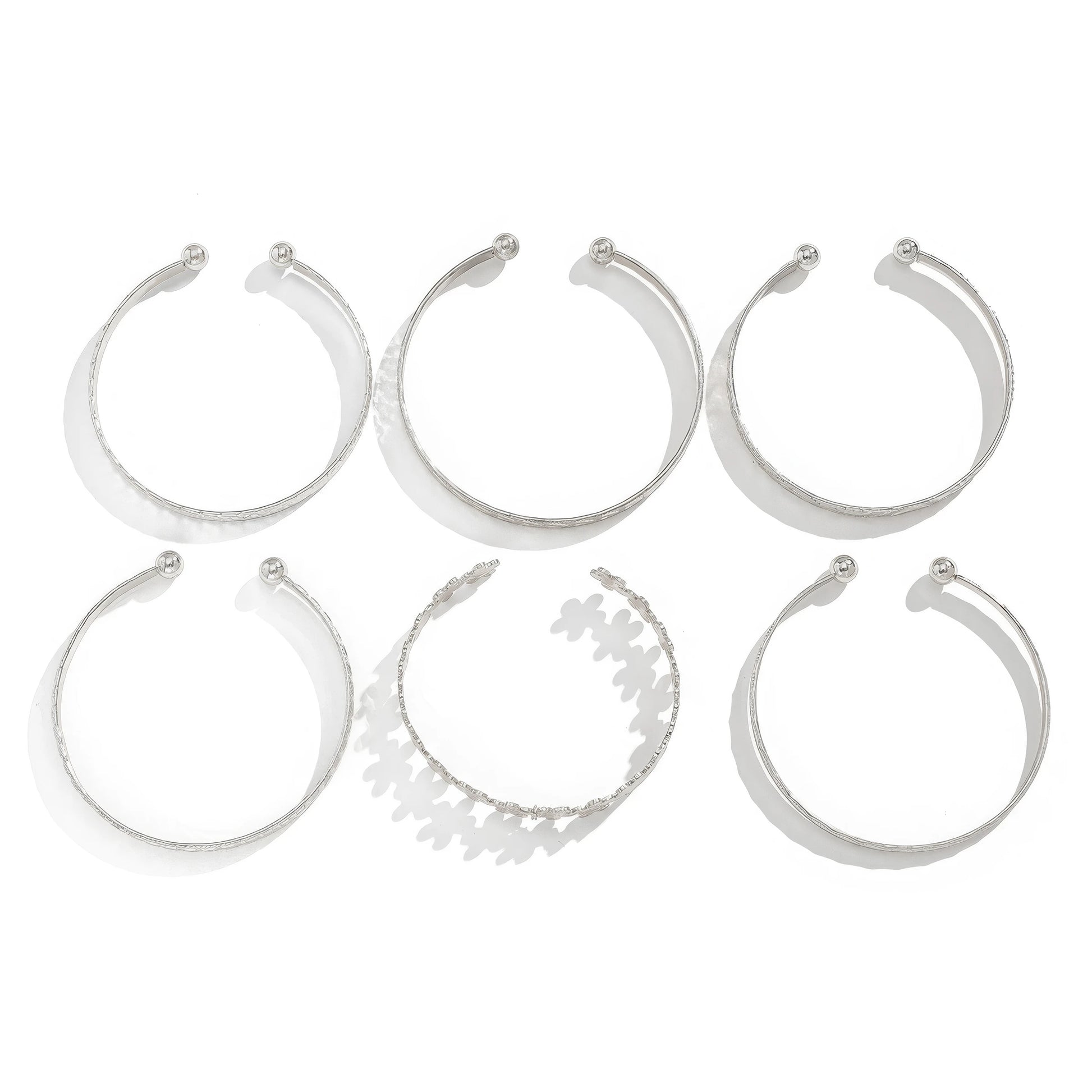 Set of silver carved pattern flower bangles, isolated on white background