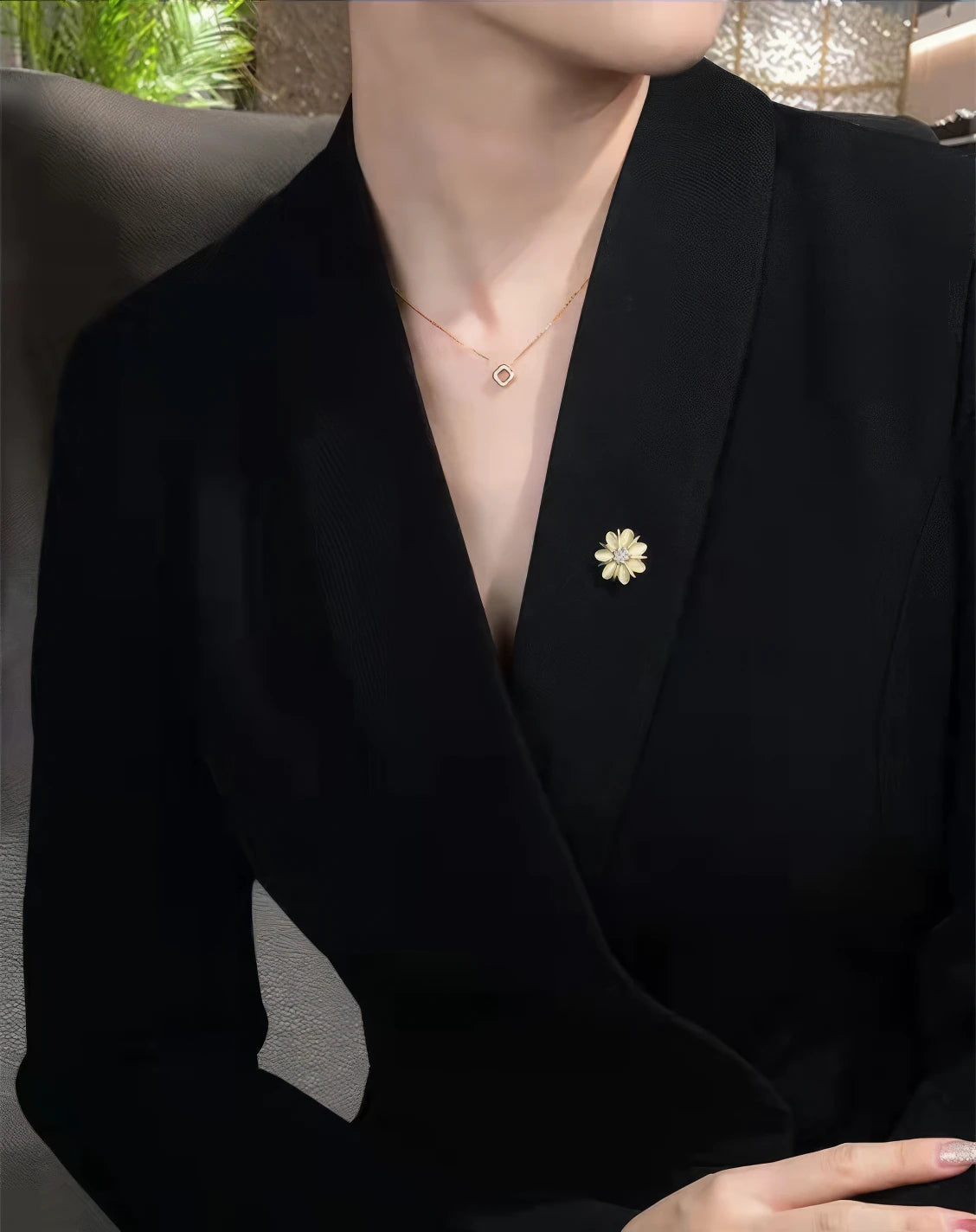 Small cat - eye stone brooch worn on black jacket, showcasing understated charm