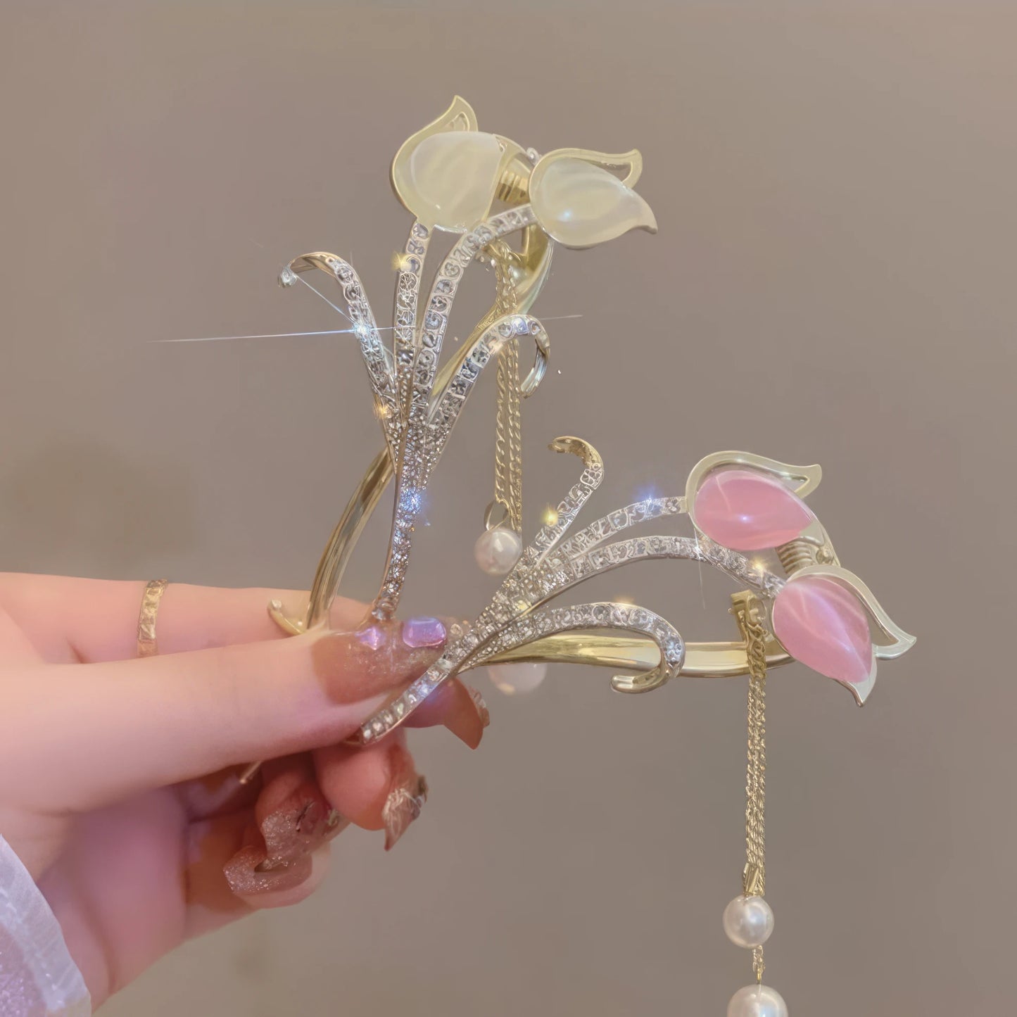 Hand holding white cat - eye stone tulip tassel hair clip