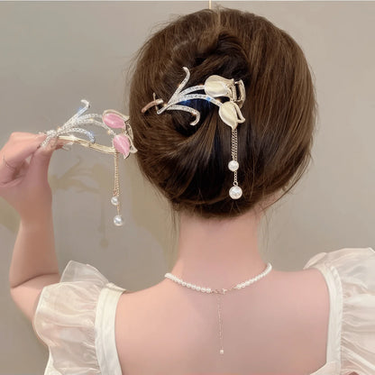 Hand holding white cat - eye stone tulip tassel hair clip