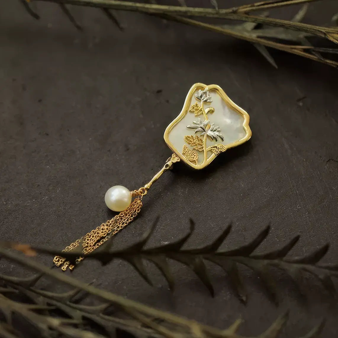 Crimson butterfly-shaped Chinese-style brooch with enamel flowers and silver tassels, on dark background
