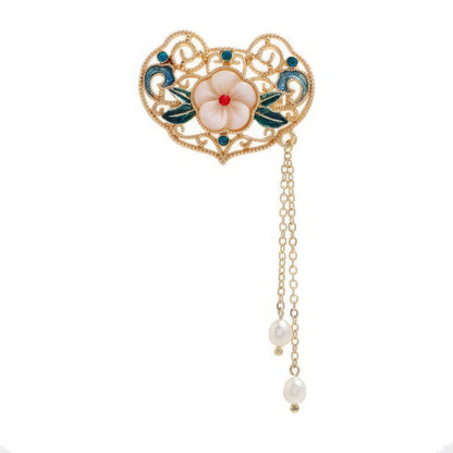 Heart - shaped Chinese - style flower tassel brooch with flower decoration, on wooden background