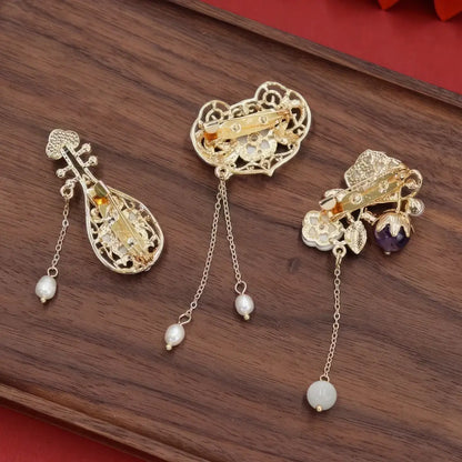 Set of Chinese - style flower tassel brooches, including lute - shaped and flower - shaped ones, on wooden background