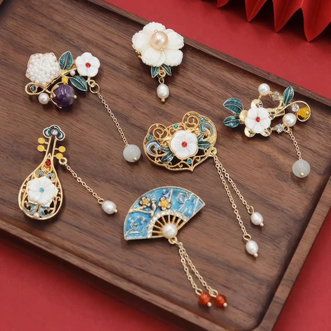 Set of Chinese - style flower tassel brooches, on wooden background