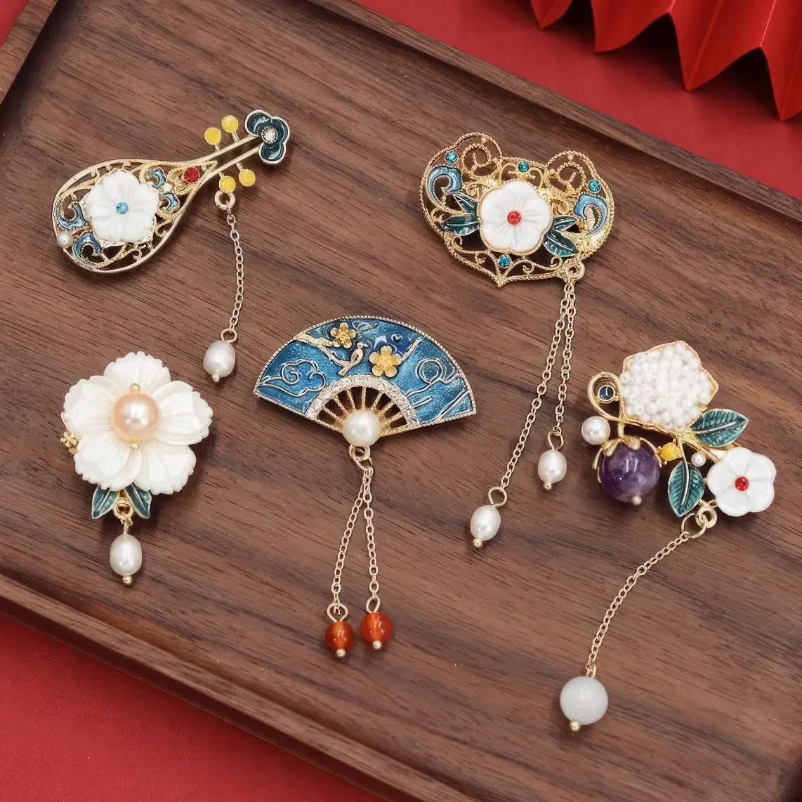 Set of Chinese - style flower tassel brooches, including lute - shaped and flower - shaped ones, on wooden background