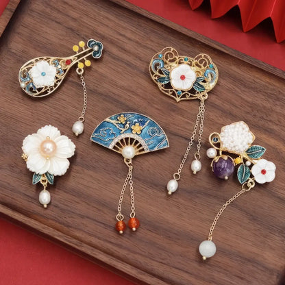 Set of Chinese - style flower tassel brooches, including lute - shaped and flower - shaped ones, on wooden background