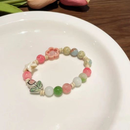 Colorful ceramic flower bracelet placed on a white plate