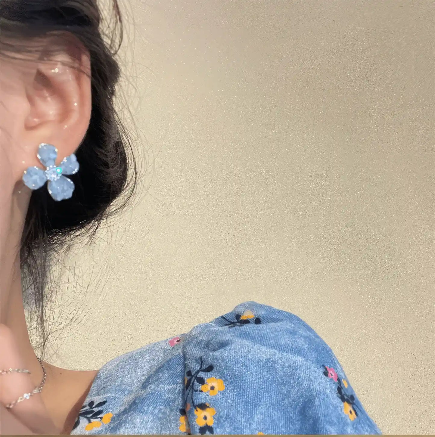 Crystal flower earrings, blue style, worn on ear with blue dress