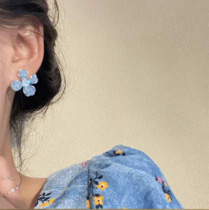 Crystal flower earrings, blue style, worn on ear with blue dress