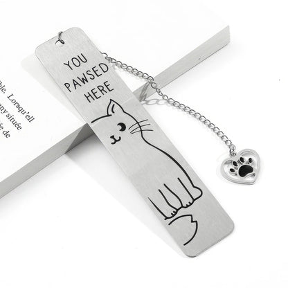 Cute cat stainless steel bookmark with chain and paw charm, displayed on book, white background