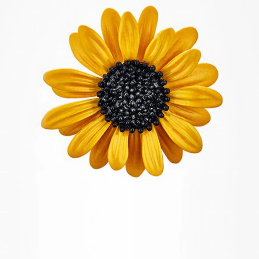 Yellow daisy brooch with black center, isolated on white background