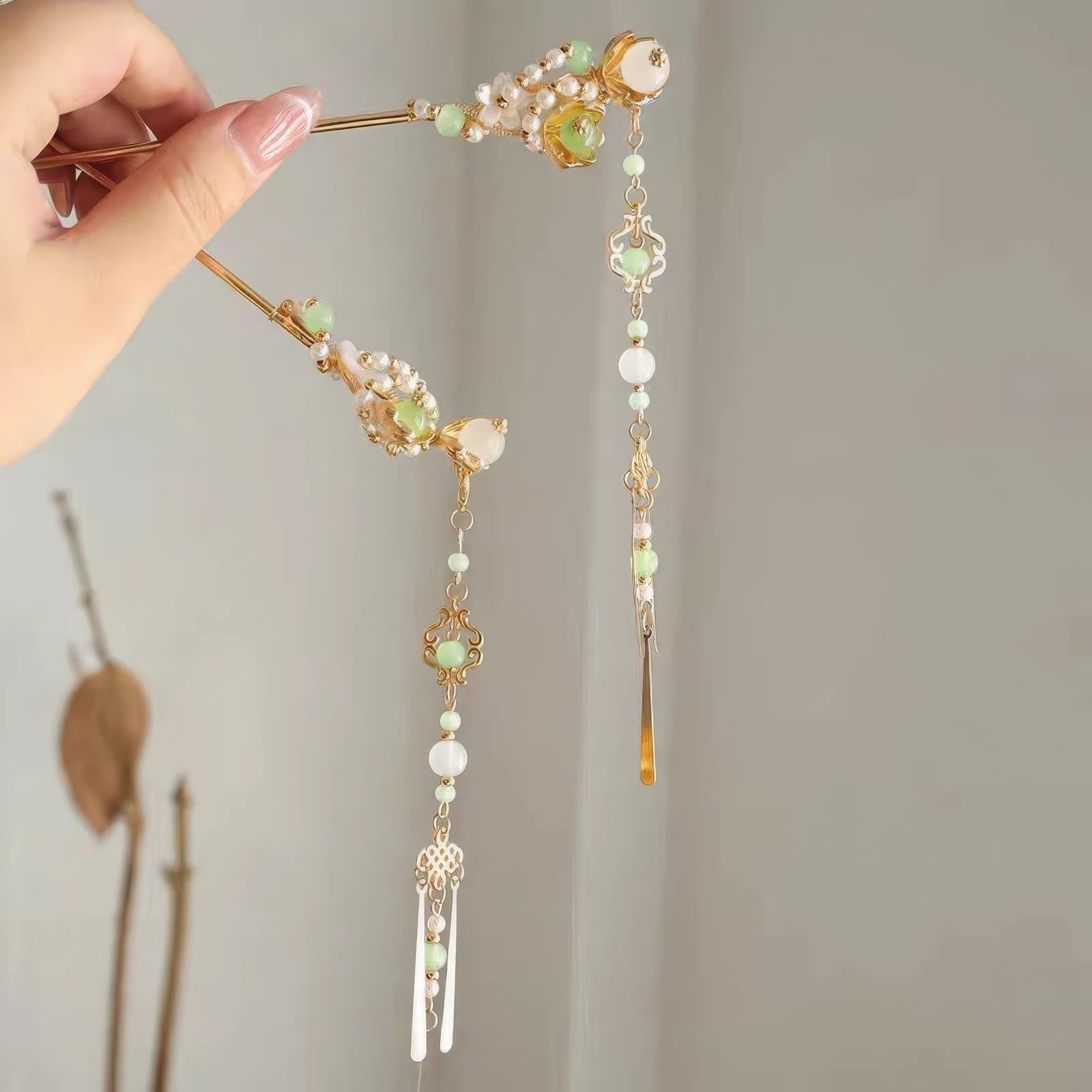 Detachable tassel hairpin held in hand, showing both the hairpin and separate tassel components