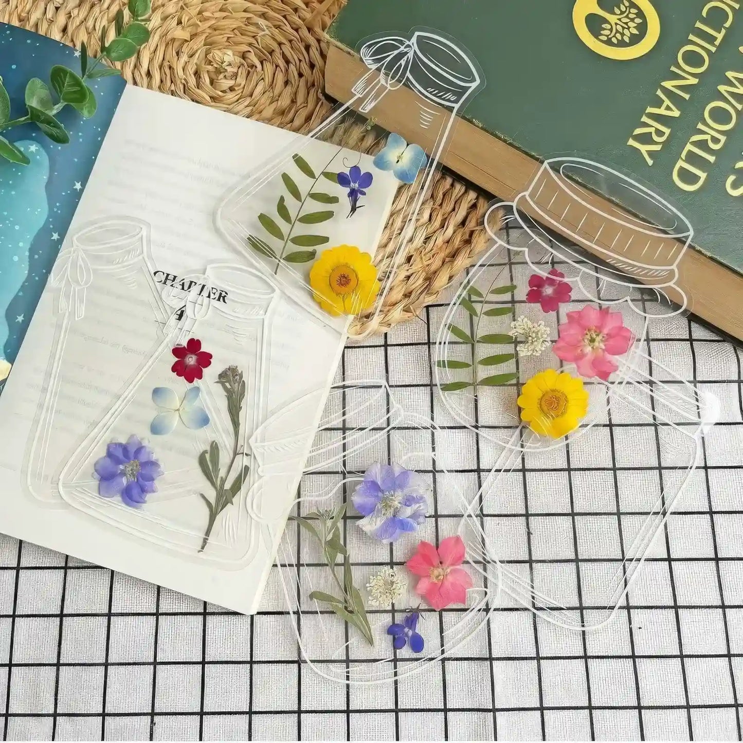Transparent bookmark with jar outlines, filled with colorful pressed flowers, on light green background