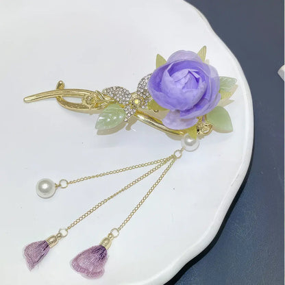 Isolated view of an elegant purple flower twist hairpin on a white plate