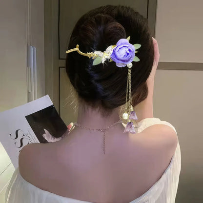 Woman wearing an elegant purple flower twist hairpin, side back view, light - colored dress