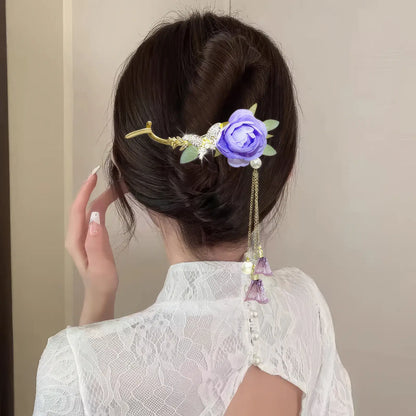 Woman wearing an elegant purple flower twist hairpin, back view, white lace top
