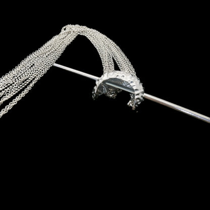 Close - up detail of extra - long tassel hairpin, black background