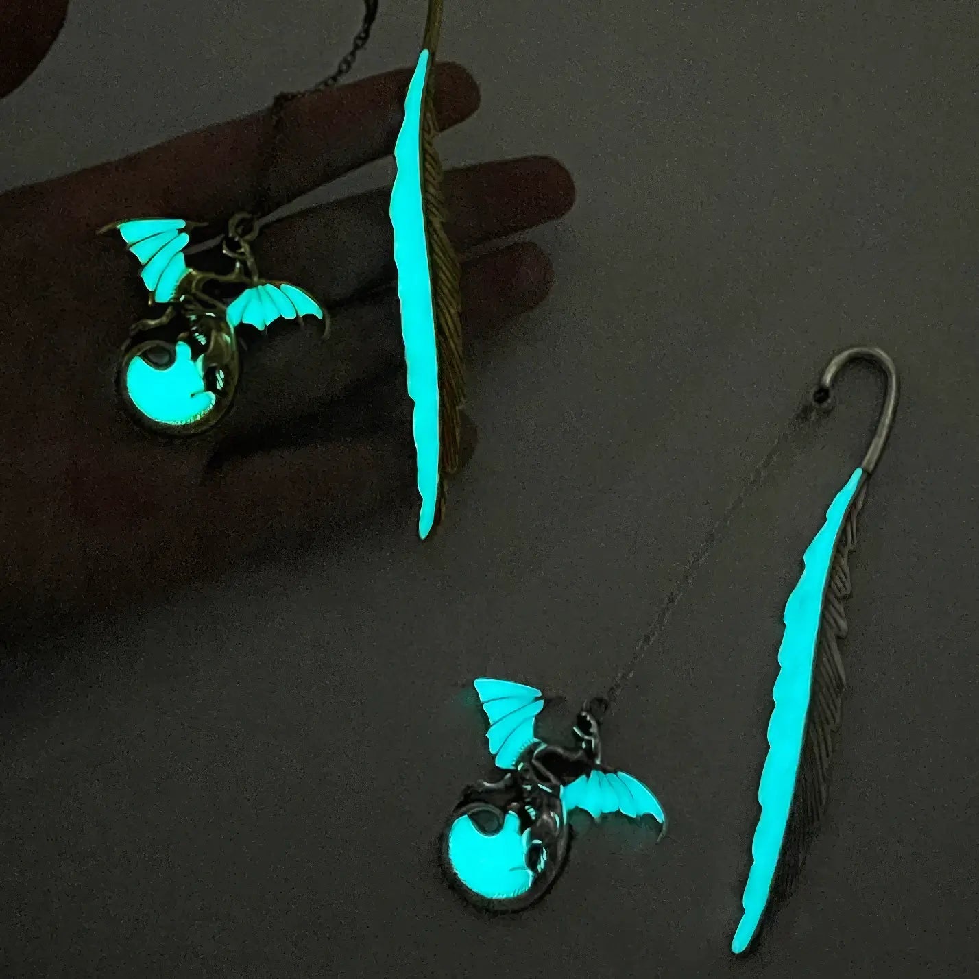 Feather four - winged dragon glow - in - the - dark bookmarks, glowing in dark environment, close - up view