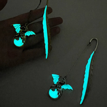 Feather four - winged dragon glow - in - the - dark bookmarks, glowing in dark environment, close - up view