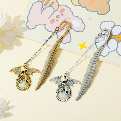 Set of feather four - winged dragon glow - in - the - dark bookmarks, displayed on light background with cute patterns