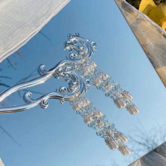 Fengjiu hairpin, silver with pearl tassels, against blue sky and white fabric