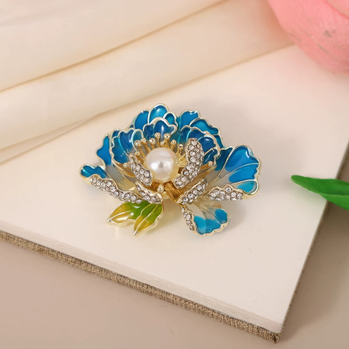 First Bloom Brocade brooch, blue flower with pearl and diamonds, on white card