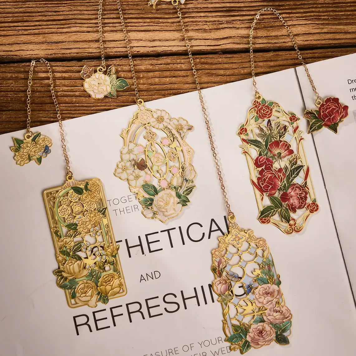 Multiple floral story bookmarks in different packages, displayed on wooden surface with stationery in background