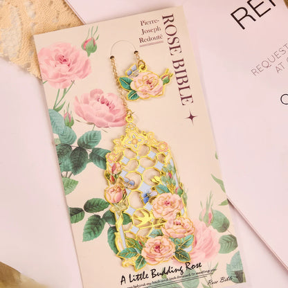 Floral story bookmark in pink package, displayed on light surface with stationery in background
