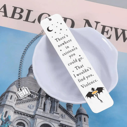 White four - winged dragon metal bookmark, placed on blue - and - white themed background