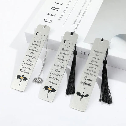 Set of white four - winged dragon metal bookmarks with tassels, displayed on white background