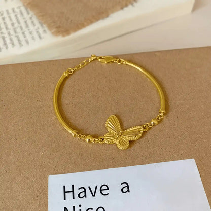 Gold butterfly bracelet displayed on a “Have a Nice” card, light surface