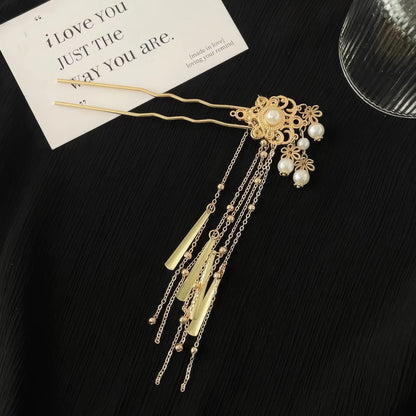 Gold pearl tassel hairpin at an angle, highlighting dangling chains