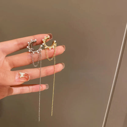 Hands holding gold and silver tassel diamond earrings