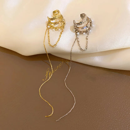 Gold and silver tassel diamond earrings placed on fabric