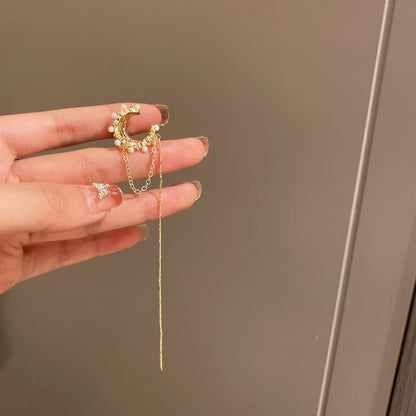 Hand holding a single gold tassel diamond earring