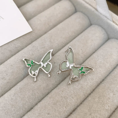 Green and blue crystal butterfly earrings on a display tray