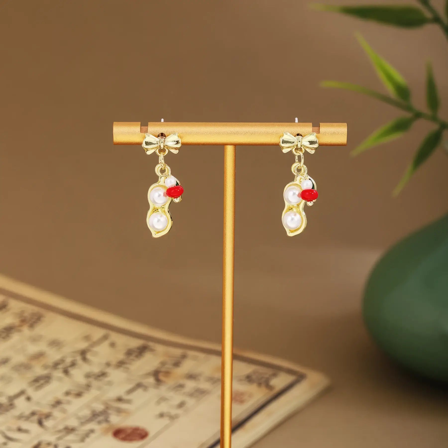 Small fan earrings with light green drops on gold hanger, green vase and scroll